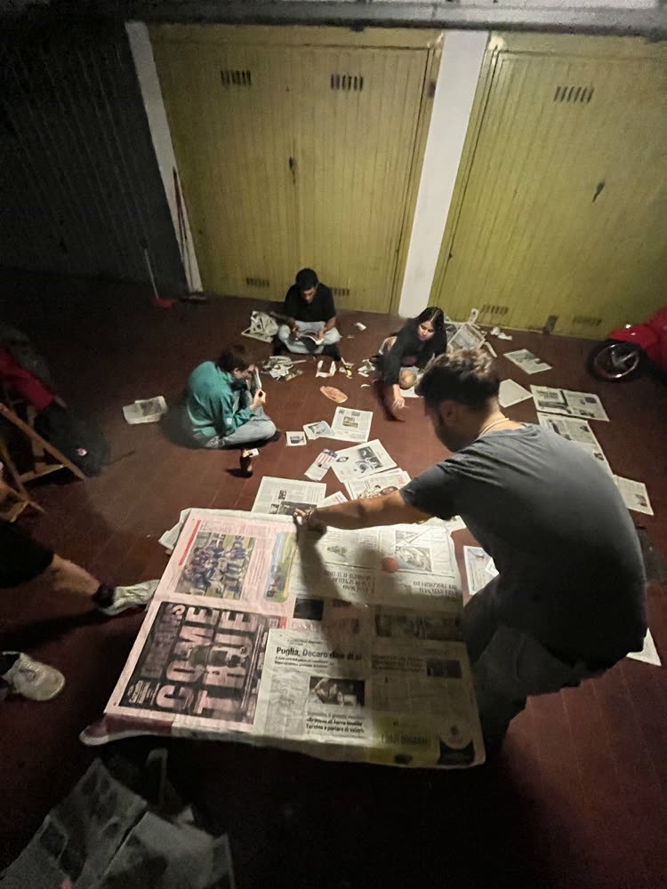 Everyone sitting on the floor, newspapers spread out between them