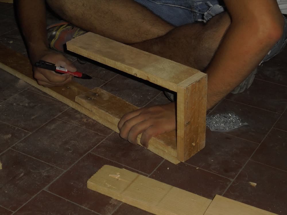 Cutting a length of reclaimed timber by hand