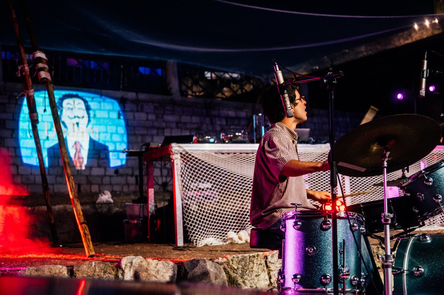 Drummer playing in front of a projection