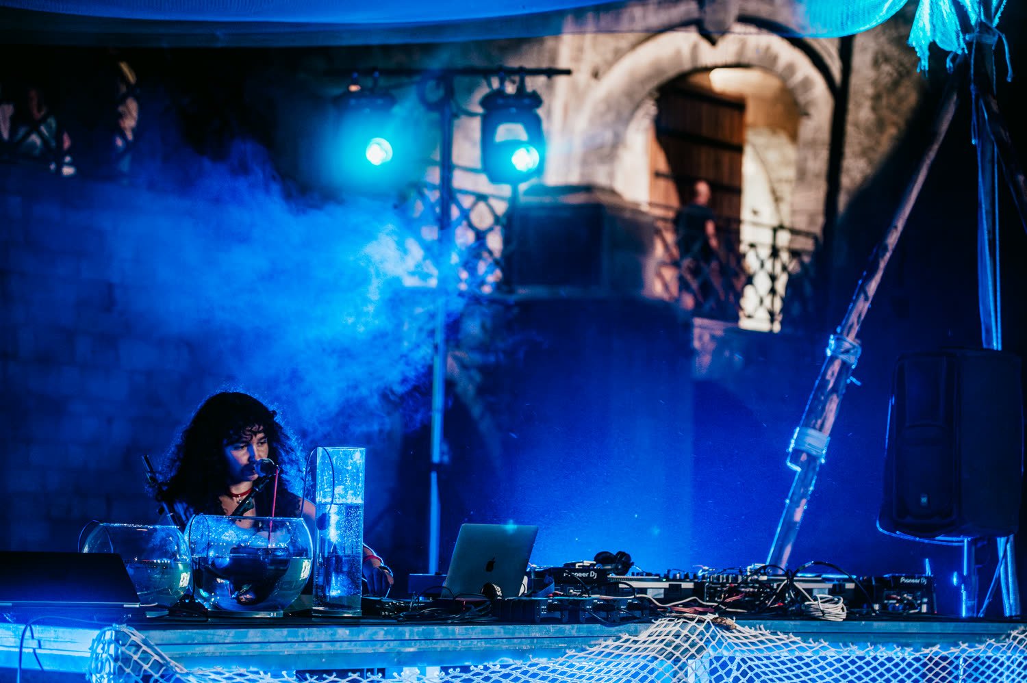 DJ set framed by scaffolding and net