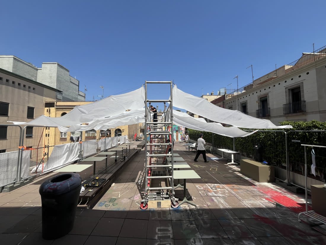 Tensioning the reused textile between the towers
