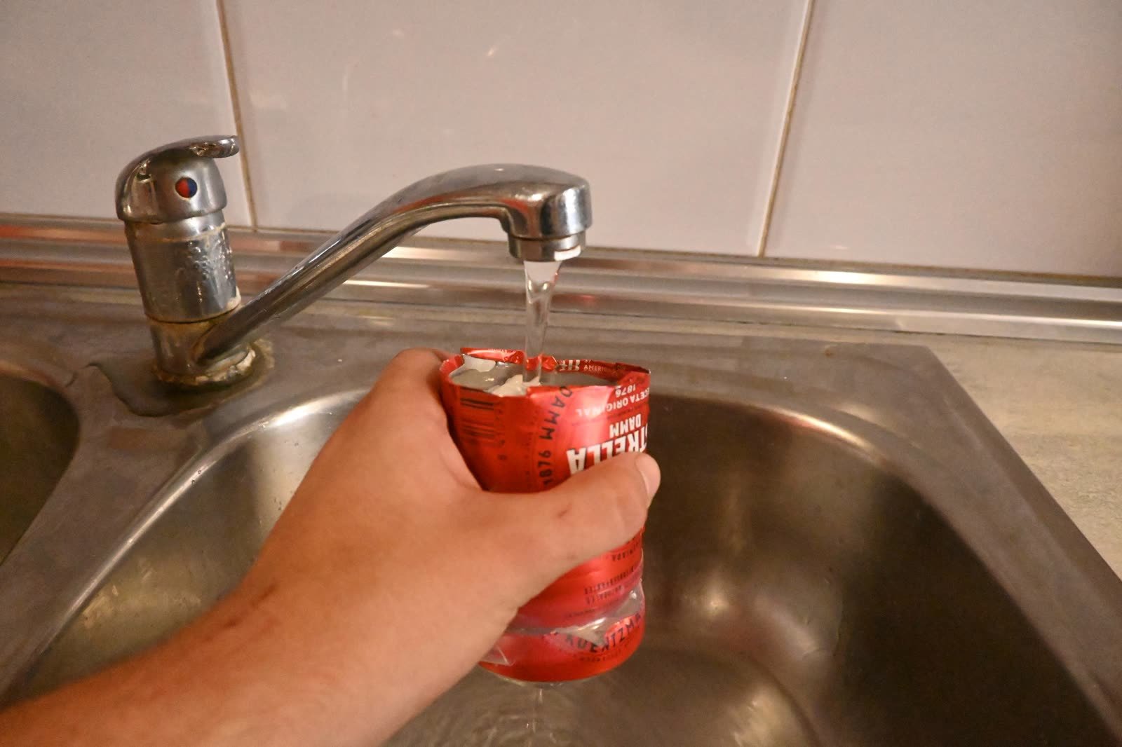 A beer can turned into a water filter, under the tap